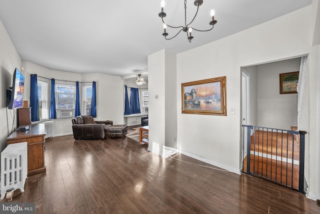 living room with ceiling fan with notable chandelier, cooling unit, radiator, and dark wood-type flooring