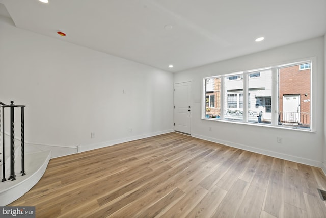 spare room featuring recessed lighting, light wood-style flooring, and baseboards