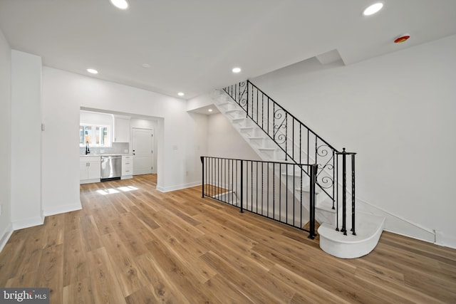 staircase featuring hardwood / wood-style flooring and sink