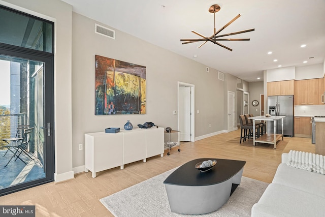 living room featuring light hardwood / wood-style flooring and an inviting chandelier