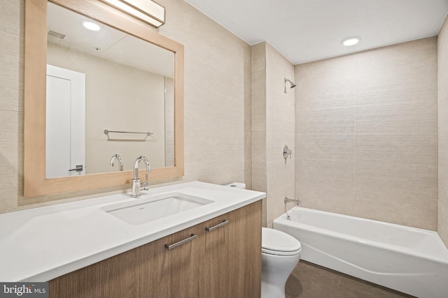 full bathroom featuring tile patterned floors, vanity, toilet, and tiled shower / bath