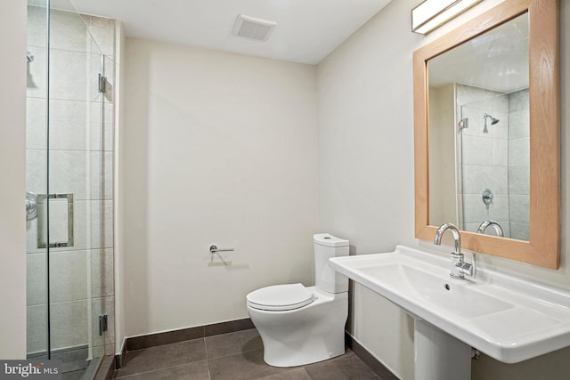 bathroom featuring tile patterned flooring, toilet, an enclosed shower, and sink