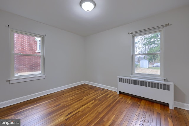 empty room featuring radiator and dark wood-type flooring