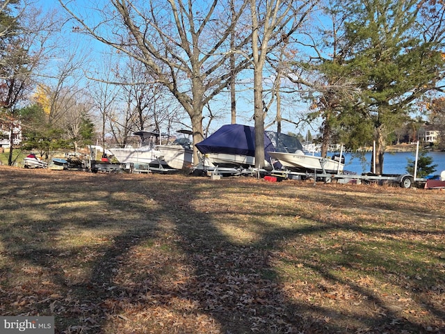 view of yard featuring a boat dock and a water view