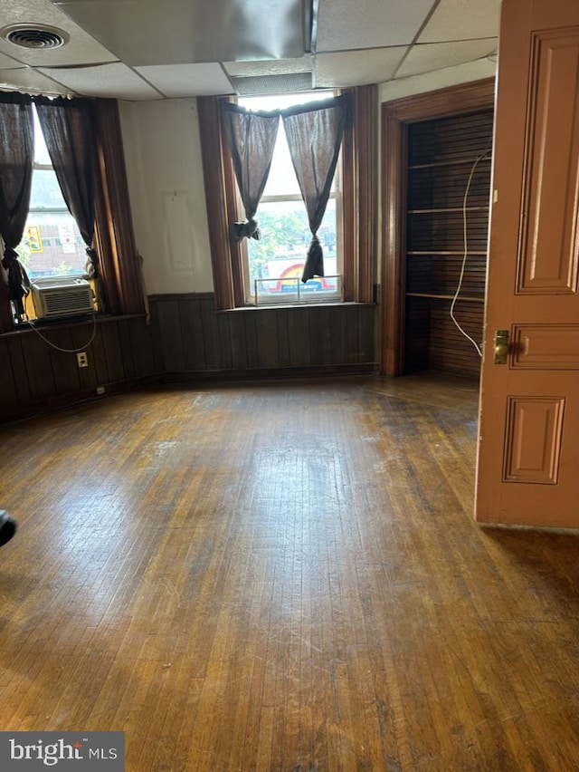 empty room featuring a paneled ceiling and hardwood / wood-style floors