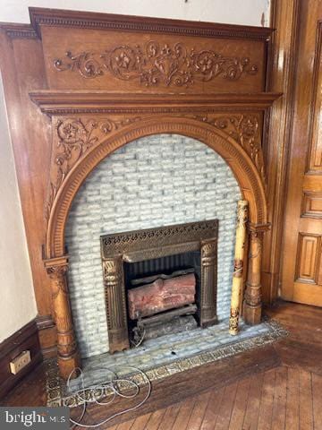 interior details with hardwood / wood-style floors and a tile fireplace