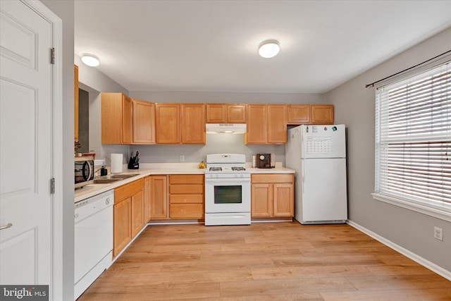 kitchen with light brown cabinets, light wood-type flooring, white appliances, and sink