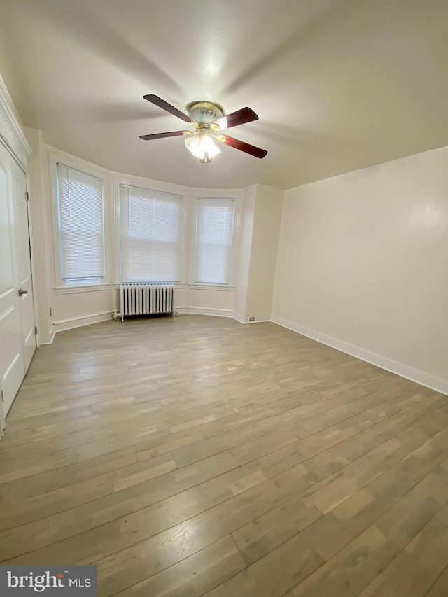 bonus room featuring ceiling fan, radiator, and light hardwood / wood-style flooring