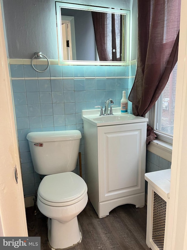 bathroom featuring toilet, vanity, tile walls, and hardwood / wood-style flooring