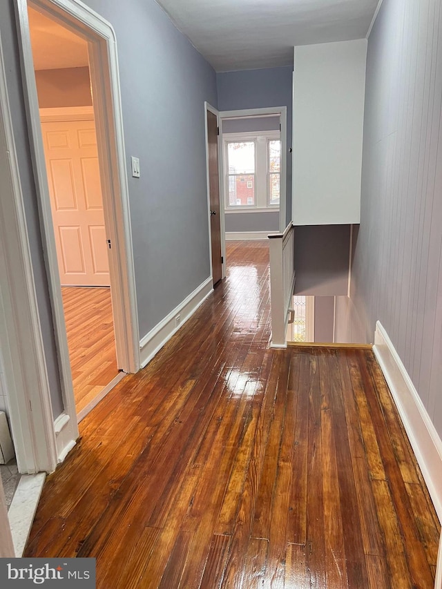 hall with hardwood / wood-style flooring and wood walls