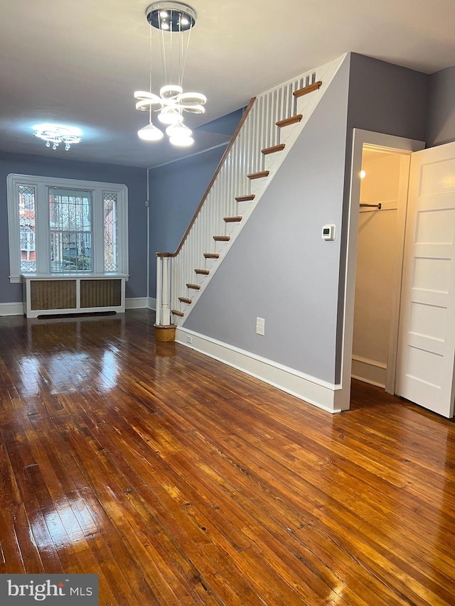 unfurnished living room with dark hardwood / wood-style floors and a notable chandelier