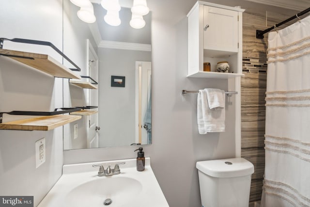 bathroom featuring a shower with shower curtain, toilet, crown molding, and sink