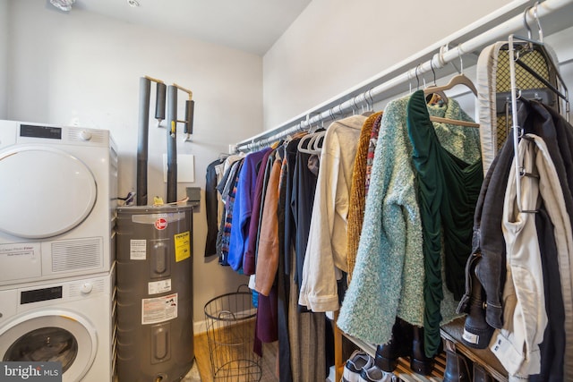 laundry room featuring stacked washer and dryer and water heater