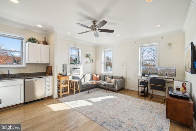 living room featuring a healthy amount of sunlight, crown molding, and light hardwood / wood-style flooring