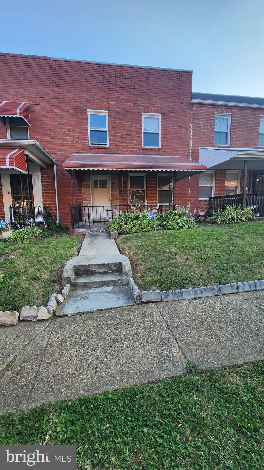 view of front of property with a front lawn, a porch, and brick siding