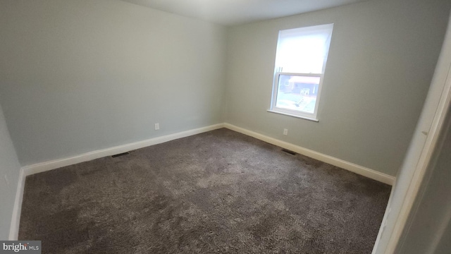 unfurnished room featuring carpet flooring, visible vents, and baseboards