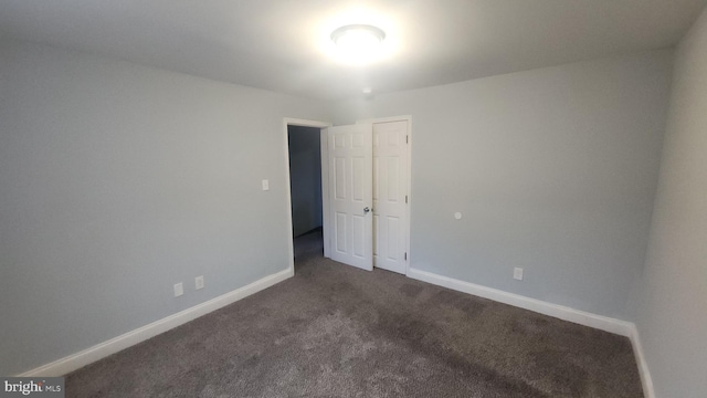 carpeted spare room featuring baseboards