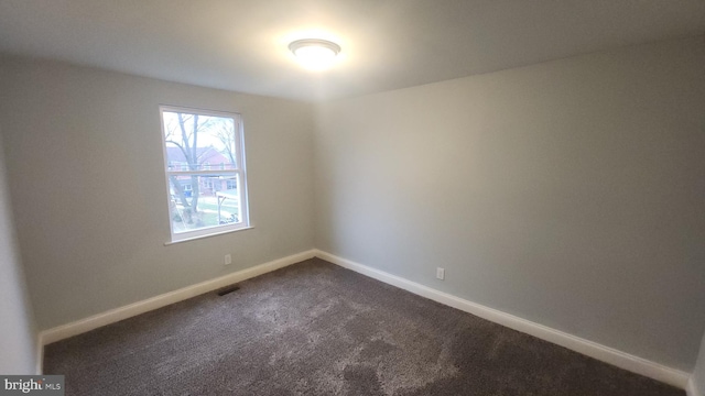 unfurnished room featuring carpet, visible vents, and baseboards