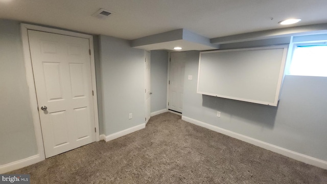 basement with carpet floors, visible vents, and baseboards