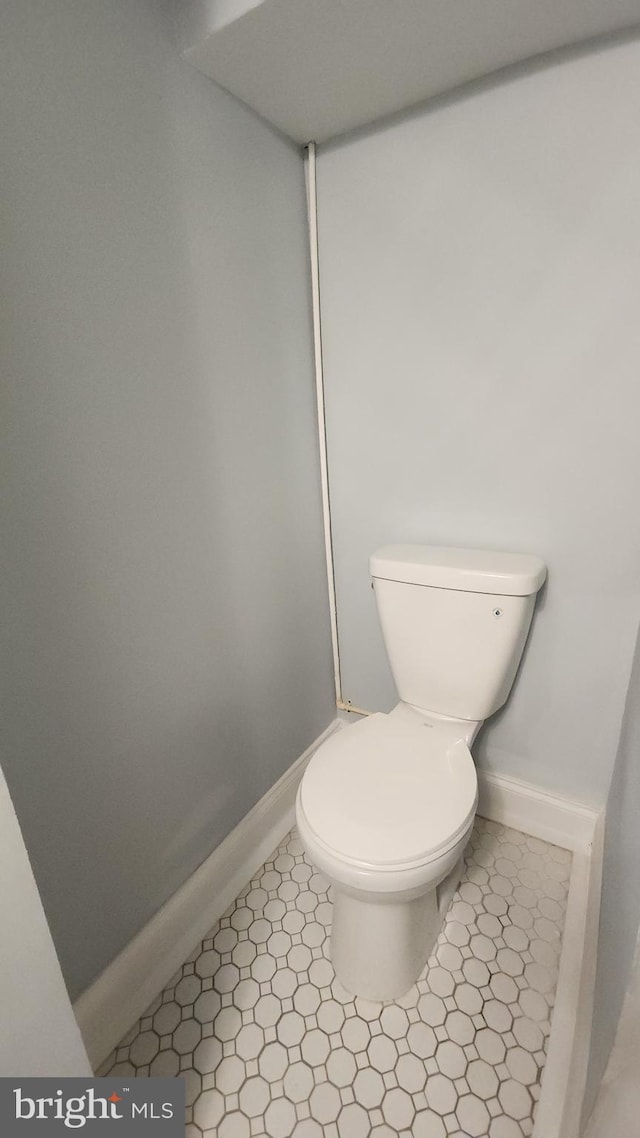 bathroom with baseboards and toilet