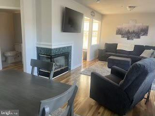 living room with hardwood / wood-style floors and a multi sided fireplace