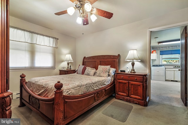 bedroom with ceiling fan, dark colored carpet, a baseboard radiator, and washer / dryer