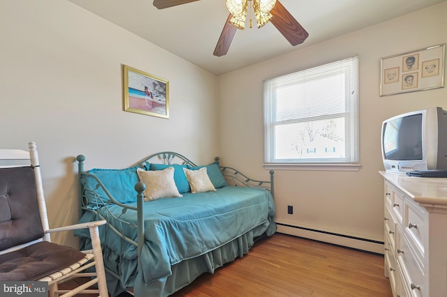 bedroom with ceiling fan, a baseboard radiator, and light wood-type flooring