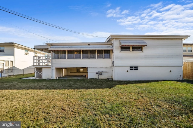 rear view of house featuring a yard and a sunroom