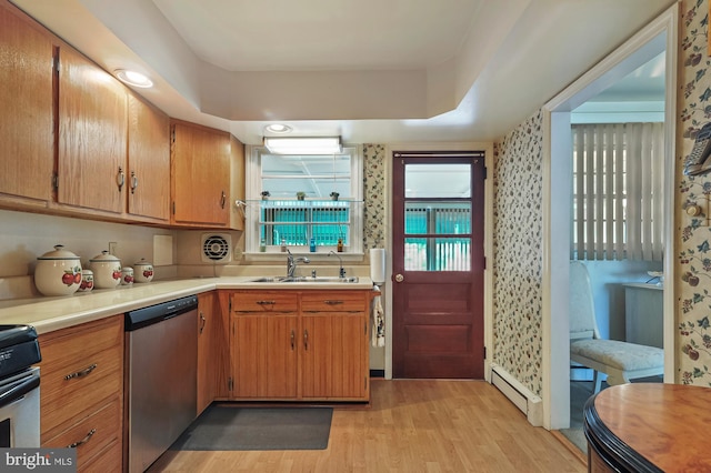 kitchen with a raised ceiling, sink, light wood-type flooring, appliances with stainless steel finishes, and a baseboard radiator