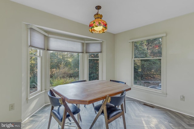 dining space with parquet flooring and a wealth of natural light