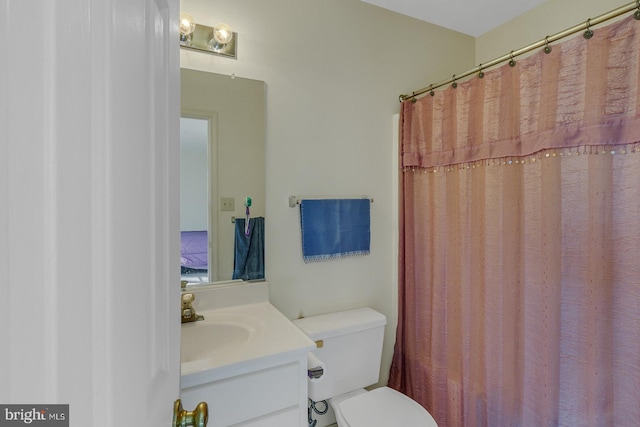 bathroom featuring vanity, a shower with shower curtain, and toilet