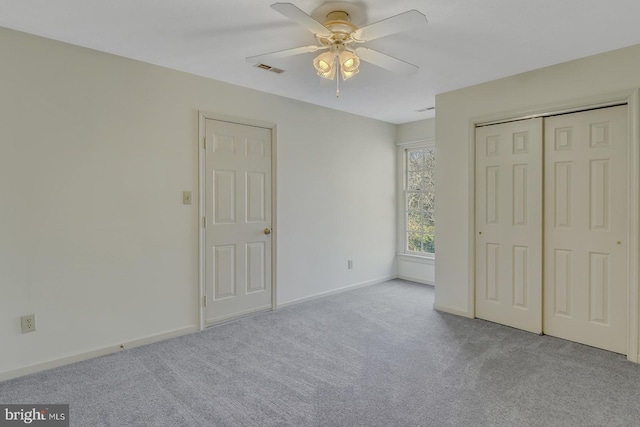 unfurnished bedroom featuring ceiling fan, light carpet, and a closet