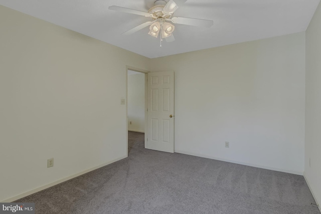 carpeted spare room featuring ceiling fan