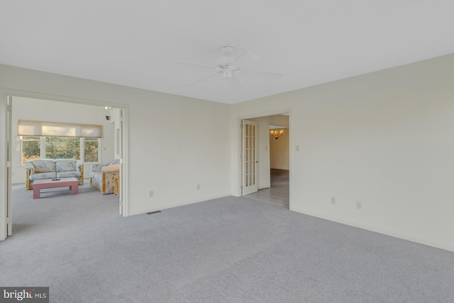 empty room featuring ceiling fan and light colored carpet