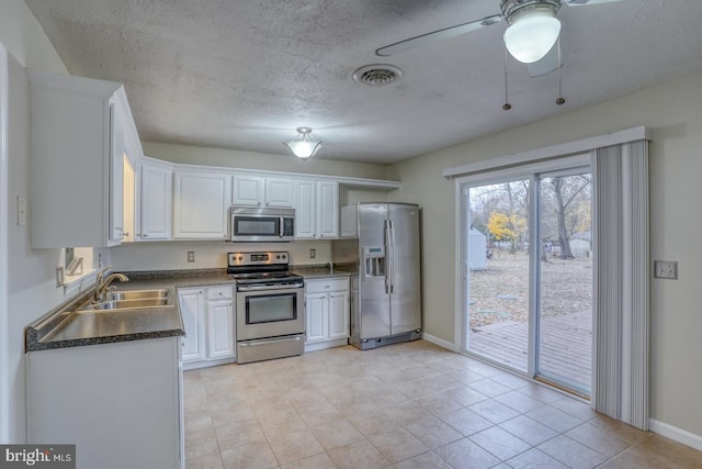 kitchen featuring white cabinets, stainless steel appliances, light tile patterned flooring, and sink