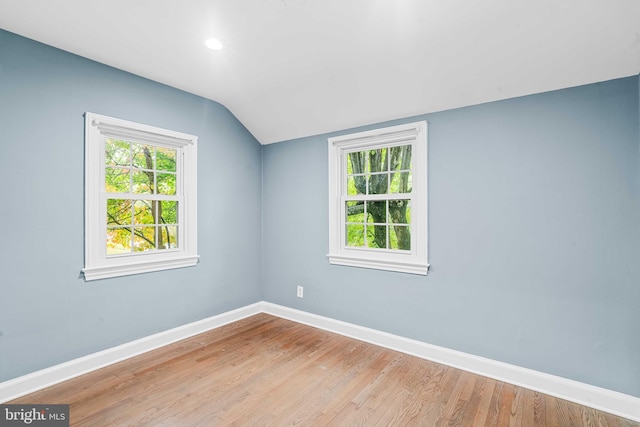 empty room with vaulted ceiling and light wood-type flooring