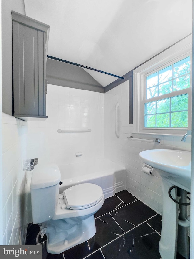 bathroom with shower / bath combination, toilet, tile walls, and lofted ceiling