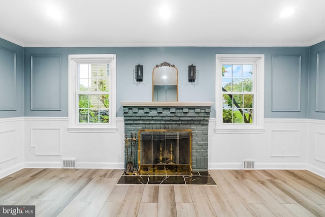 unfurnished living room featuring light wood-type flooring and a stone fireplace