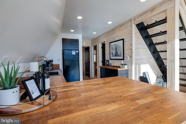 kitchen featuring sink, black refrigerator, light hardwood / wood-style floors, and wood counters