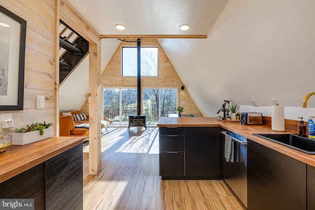 kitchen with butcher block countertops, wood walls, and light hardwood / wood-style flooring