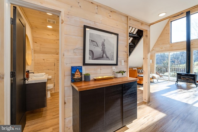 hall featuring light wood-type flooring and wooden walls