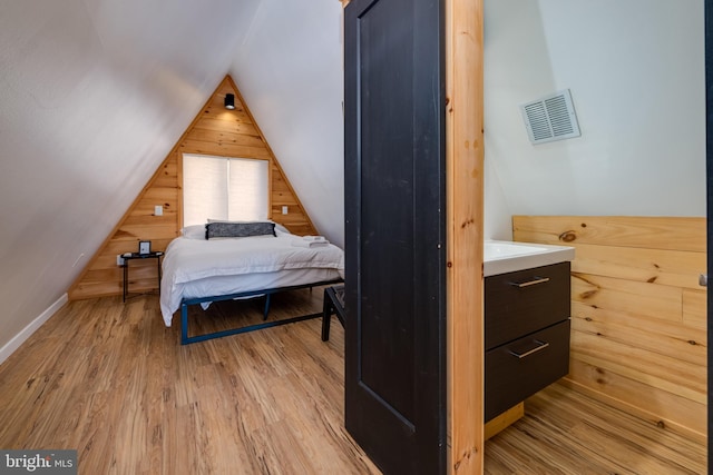 bedroom featuring light hardwood / wood-style flooring and lofted ceiling