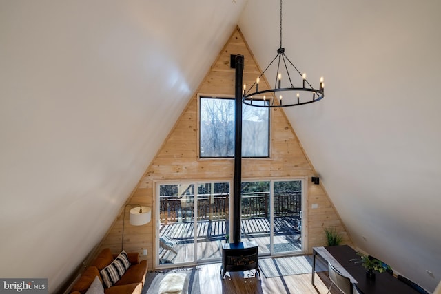 bonus room with hardwood / wood-style flooring, lofted ceiling, wooden walls, and a chandelier