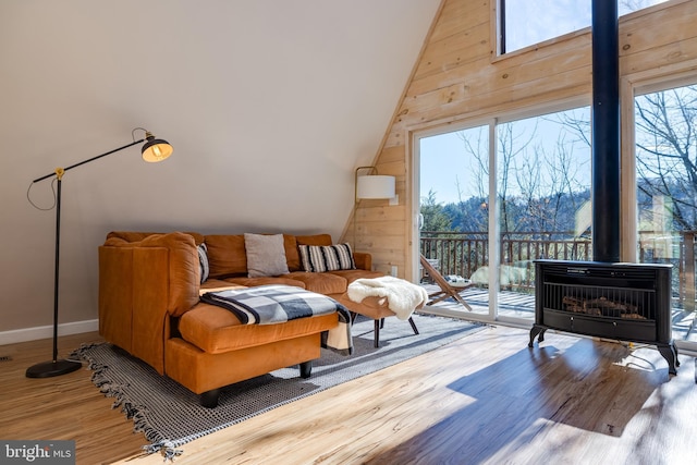 living area featuring wood-type flooring, high vaulted ceiling, and a healthy amount of sunlight