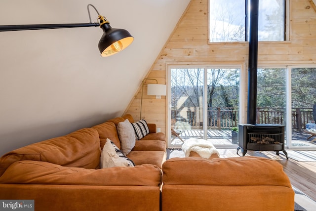 living room featuring wood walls, wood-type flooring, and a wood stove