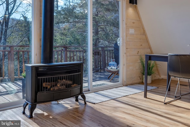 entryway featuring a wood stove, plenty of natural light, and light wood-type flooring