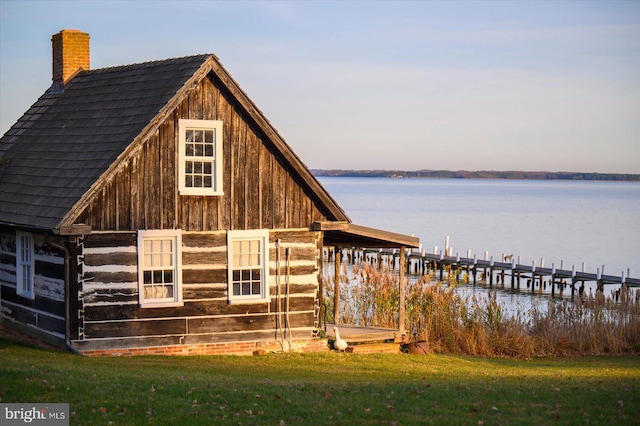 outdoor structure at dusk with a yard and a water view