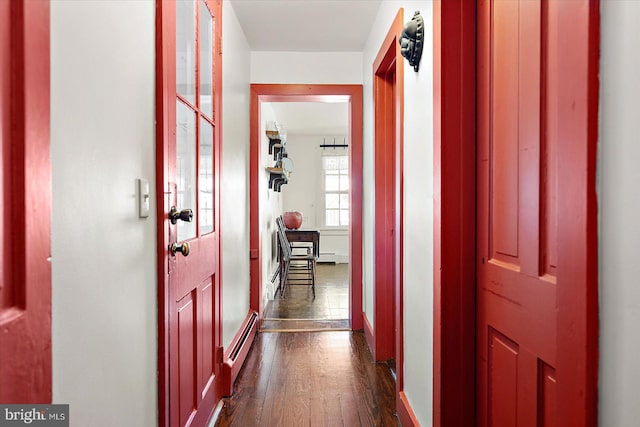 hallway with a baseboard heating unit and dark hardwood / wood-style floors