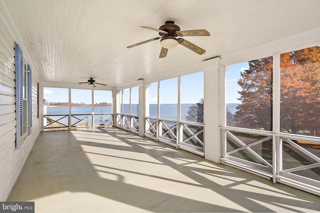 unfurnished sunroom featuring a water view and ceiling fan