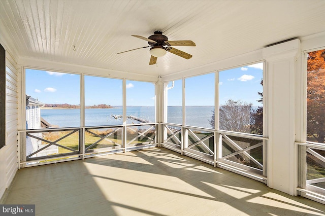 unfurnished sunroom featuring a water view and ceiling fan